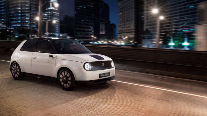 Honda e s mestom v pozadí