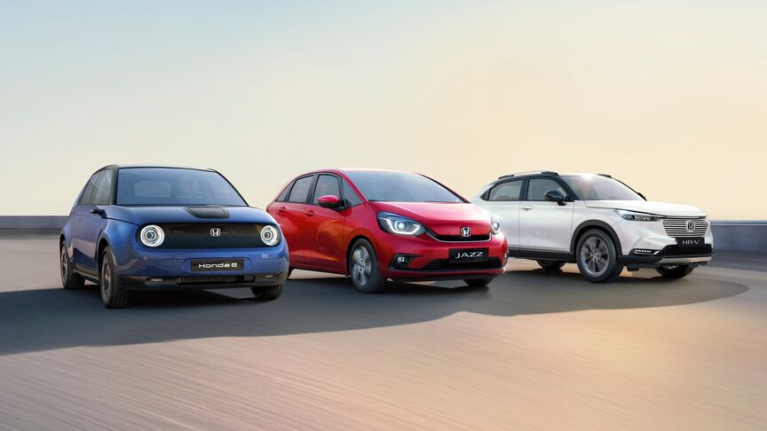 Dáma stojaca vedľa bieleho vozidla Honda e používajúca aplikáciu My Honda Plus