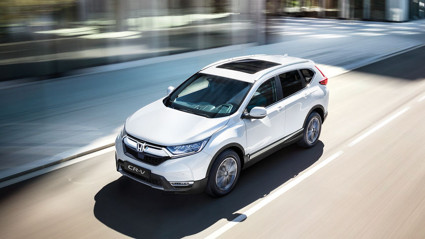 Trojštvrťový záber spredu na model CR-V pri jazde mestom.