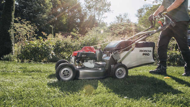 Pohľad zboku na kosačku Honda HRH, ktorá sa používa v záhrade. 