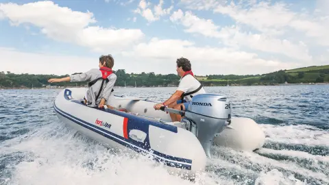 Dvaja muži v člne Honwave s motorom BF20 na vode.