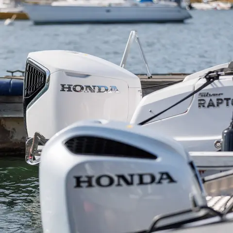 Detailný záber na motory Honda BF na lodiach vo vode.