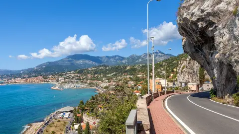 Malebná cesta pod modrou oblohou pozdĺž pobrežia Stredozemného mora na francúzsko-talianske hranice.