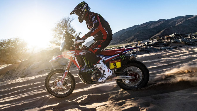 Pohľad na motocykel Honda CRF450 z ľavej strany pri jazde v piesočných dunách.