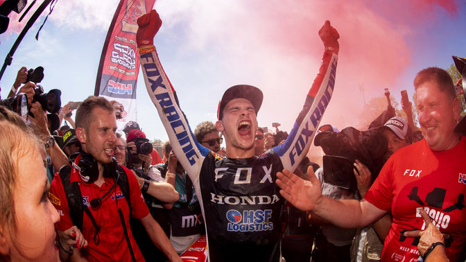 Jazdec na motocykli Honda v pretekoch MXGP oslavujúci víťazstvo.